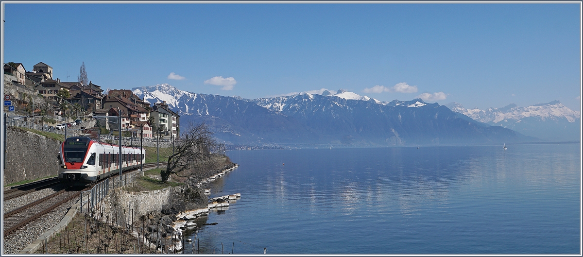 Zwischen Saint Saphorin und Rivaz ist ein SBB Flirt RABe 523 auf dem Weg in Richht Lausanne, wobei der (Foto) - Blick weit über den See in die Waadtländer Alpen schweift.

24. März 2018