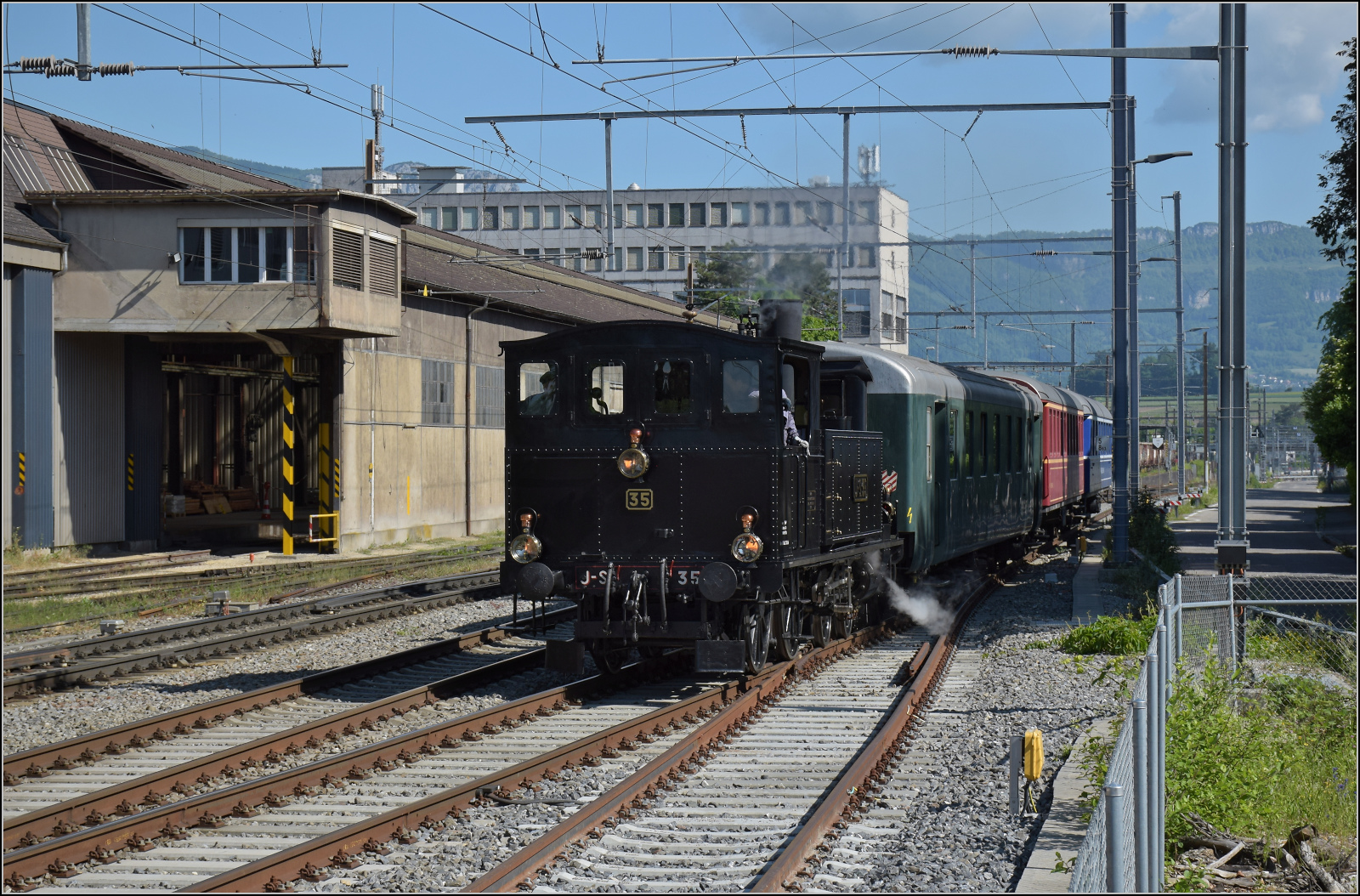 150 Jahre Emmentalbahn.

Eb 2/4 35 der Jura-Simplon fährt auf dem Weg nach Burgdorf durch Gerlafingen am Stahlwerk vorbei, einem Einnahmengaranten der Emmentalbahn und genaugenommen Keimzelle, denn von hier gingen die ersten Gleise einer Pferdebahn die Emme entlang nach Derendingen. Mai 2025.
