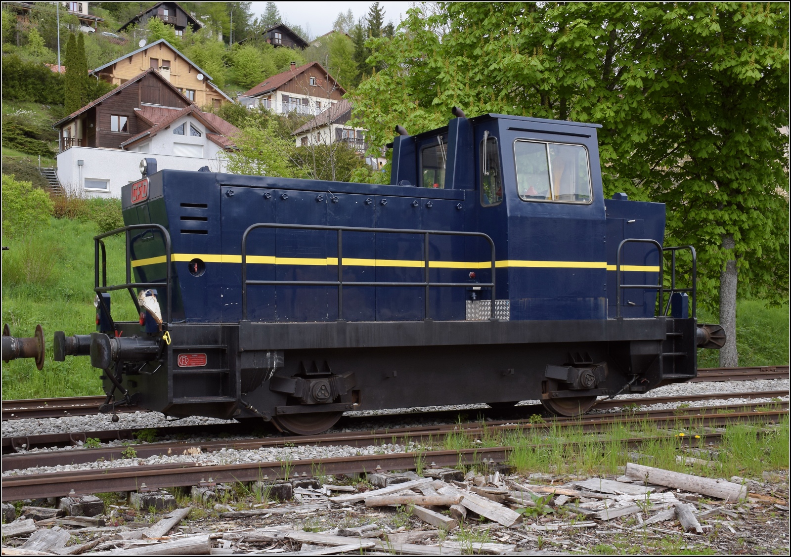 Abstecher zur Coni'fer. 

Die zweiachsige Rangierlok des Herstellers CFD im Gewand des Orientexpress ist nun abgestellt. Vermutlich handelt es sich um den Locotracteur B 350H. Les Hôpitaux-Neufs. Mai 2023.