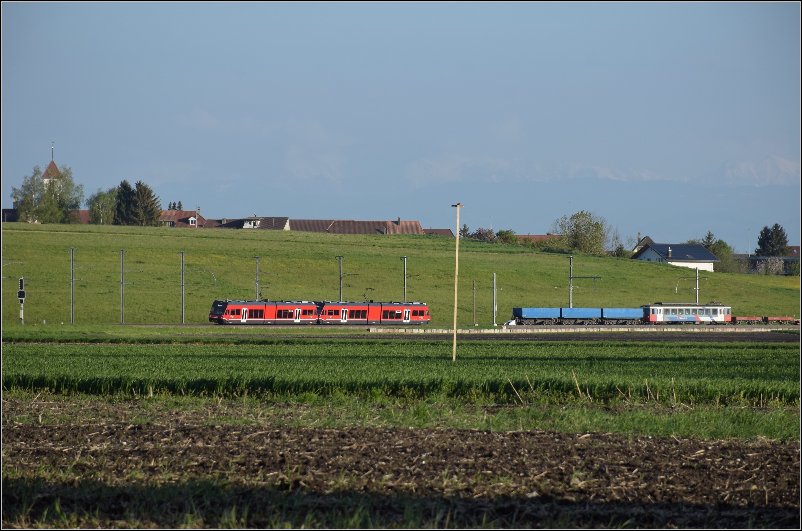 Auf der Biel-Täuffelen-Ins Bahn.

GTW Be 2/6 502 und GTW Be 2/6 507 der ASm. Noch im Bild, drei nicht mehr benötigte Kieswagen Fa 574, Fa 575 und Fa 573, der mittlerweile verschrottete Be 4/4 525 und zwei vermutlich 107 Jahre alte Niederbordwagen, K 587 und K 586. Und bei ganz genauer Betrachtung  zeichnen sich die Alpen in den blauen Himmel. Siselen, April 2022.