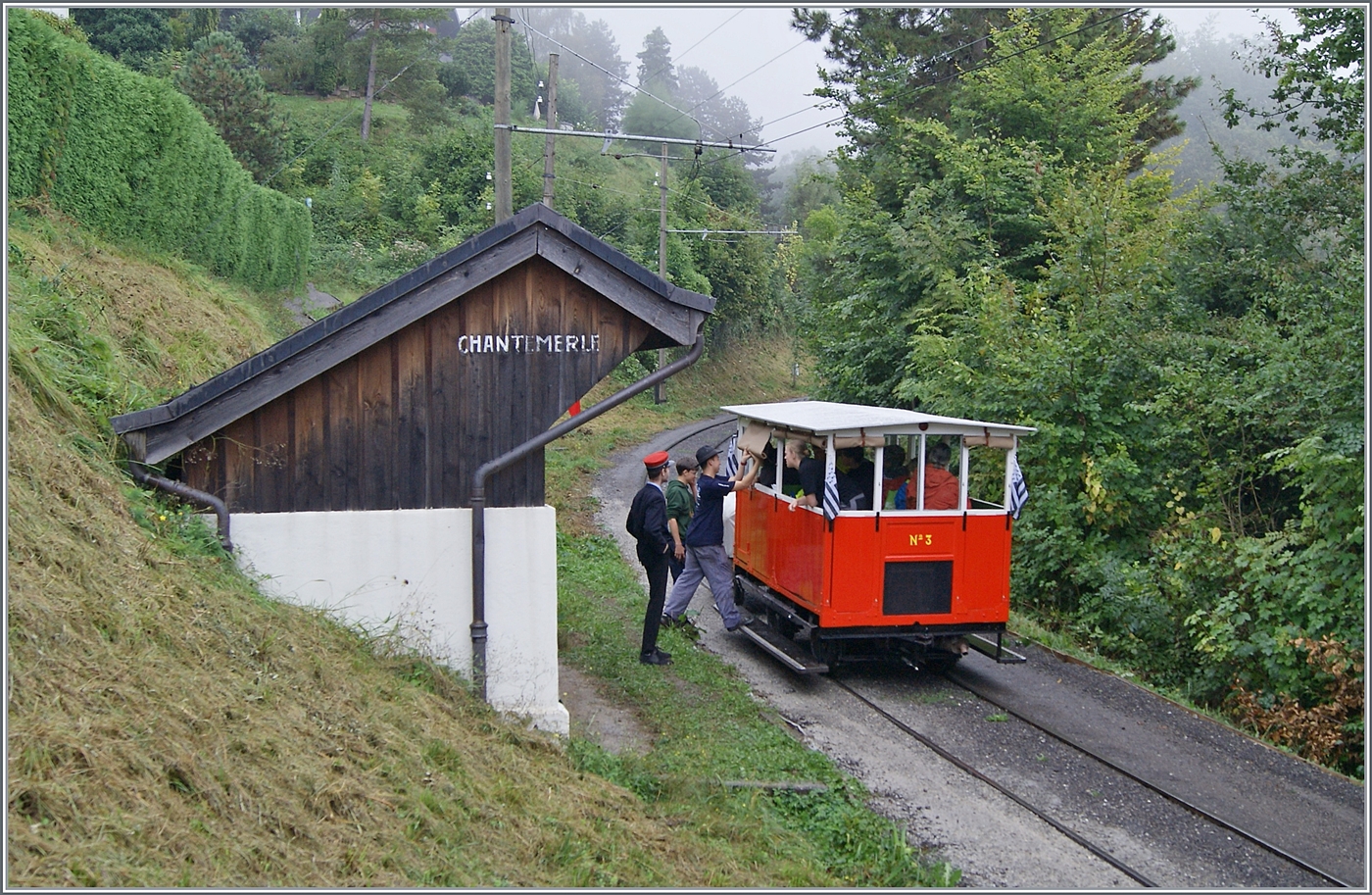 Autour de la voie ferrée / Rund um die eiserne Bahn (Herbstevent 2024) - Nachdem erstaunlich viele Reisende in der kleine Dm 2/2 N° 3  Le Biniou  Platz gefunden haben, ist der Zug praktisch für die Rückfahrt bereit. Es müssen nur noch - nach dem der Regen aufgehört hat - die Storen aufgerollt werden; ein Vorgang welcher der Chef de la Gare interessiert beaufsichtigt.

8. Sept. 2024