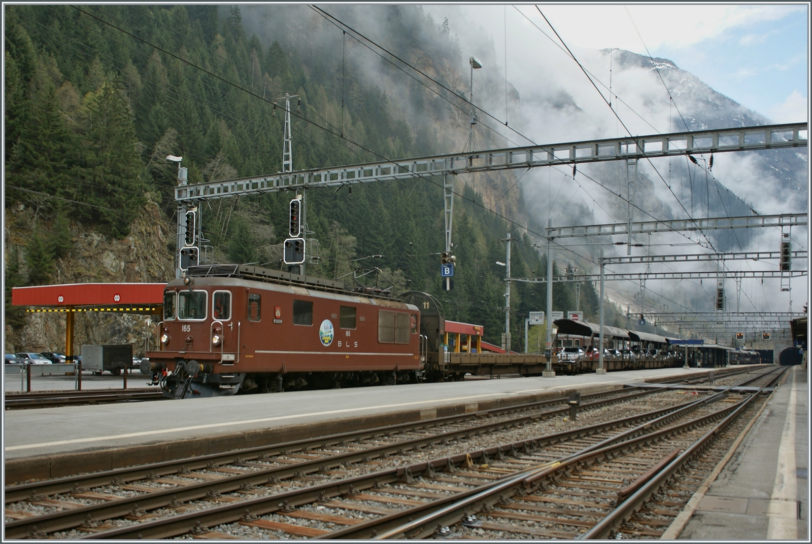 BLS Re 4/4 163 - 165 von 1967, als Ae 4/4 II 263- 265 abgeliefert; die Re 4/4 165  Moutier  verlässt mit einem Tunnelautozug Goppenstein in Richtung Kandersteg. 

4. Mai 2013
