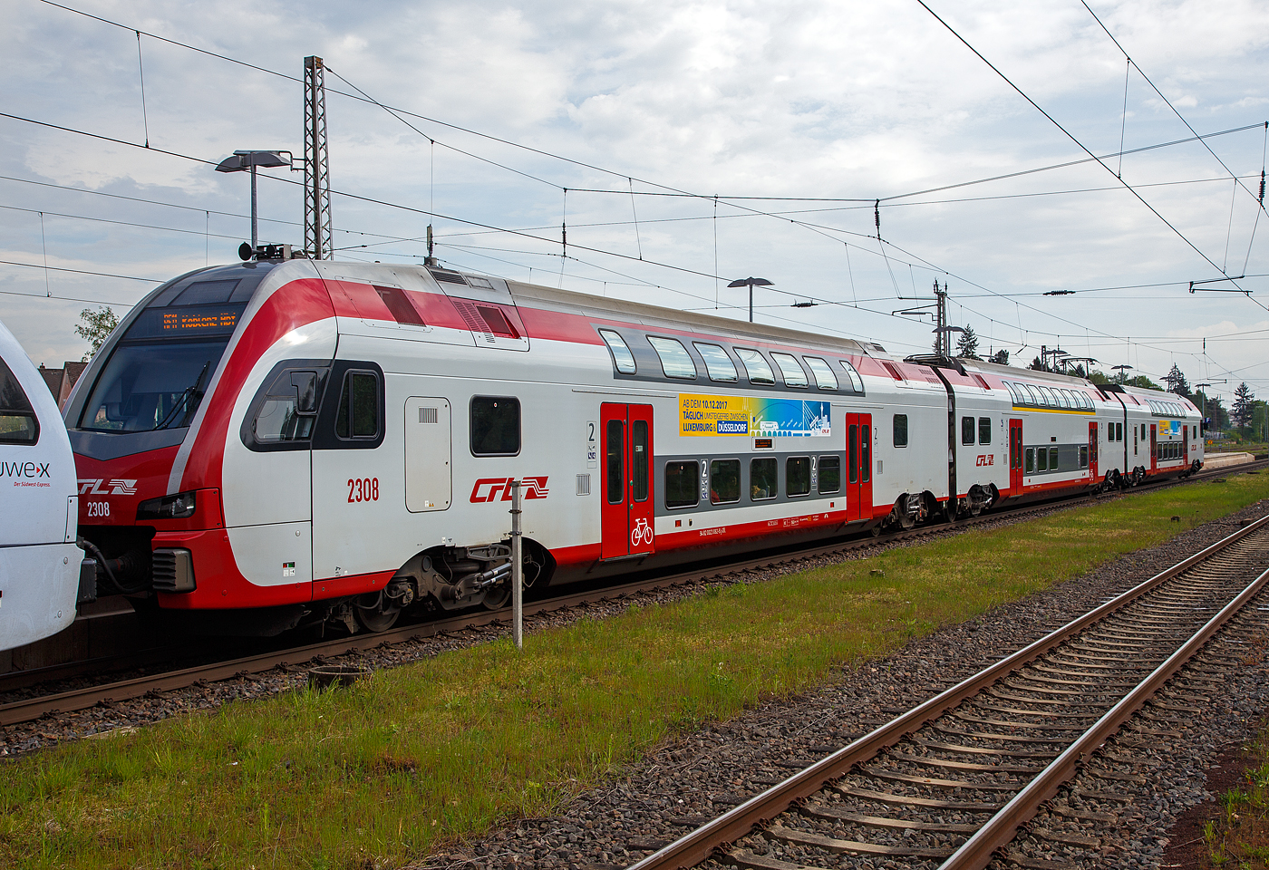 Der dreiteilige CFL Stadler KISS 2308 als RE 11  DeLux-Express  gekuppelt hier am Ende mit dem fünfteilige SÜWEX Stadler FLIRT³  - 429 116 / 429 616 als RE 1  Südwest-Express  nach Koblenz haben am 29.04.2018 den Hbf Wittlich erreicht.

Hier der führende CFL Stadler KISS 2308 als RE 11  DeLux-Express  (Luxembourg – Wasserbillig – Igel – Trier – Cochem –Koblenz). Der KISS setz sich zusammen aus den Wagen 94 82 0023 082-9 L-CFL, 94 82 0023 083-x L-CFL und 94 82 0023 081-1L-CFL. 

Diese ersten 8 KISS der 1.Serie (2301 – 2308) wurden 2013 von der Stadler Pankow GmbH (Berlin) gebaut. Weitere 13 weitere Stadler KISS der 2.Serie (2309 – 2321) wurden 2017 (11 Stück) und 2020 (2 Stück) gebaut, sie besitzen mehr Sitzplätze in der 1. Klasse.

Nach Ankündigung der DB Fernverkehr AG, drei der fünf bestehenden IC-Verbindungen zwischen Luxemburg und Koblenz zu streichen, haben das Ministerium für nachhaltige Entwicklung und Infrastruktur Luxemburg, das Ministerium des Innern, für Sport und Infrastruktur des Landes Rheinland Pfalz, die CFL, SPNV-Nord und die DB Regio AG eine Ersatzlösung ausgearbeitet.

Ab dem Fahrplanwechsel Mitte Dezember 2014 ist wie folgt vorgesehen: Eine stündliche Zugverbindung zwischen Luxemburg und Koblenz, mit Flügelung der von Saarbrücken kommenden Züge (dann FIRT 3) in Trier. Die Verbindung Luxemburgs mit dem deutschen Fernverkehrsnetz wird somit deutlich verbessert.

Die CFL (Société Nationale Chemins de Fer Luxembourgeois) hat acht dieser dreiteiligen doppelstöckigen Triebwagen bei Stadler gekauft (mit einer Option auf 31 weitere), diese wurden bei Stadler Pankow GmbH gebaut. Die Fahrzeuge sind mit ETCS ausgestattet und erreichen eine Höchstgeschwindigkeit von 160 km/h. Sie können unter den Stromsystemen 25 kV, 50 Hz (in Luxemburg) und 15 kV, 16,7 Hz (in Deutschland) verkehren.

Die KISS, die von der Stadler Pankow GmbH gefertigt werden, unterscheiden sich vom ursprünglichen KISS-Modell dadurch, dass sie das Lichtraumprofil G2 einhalten, um auf dem Netz der DB Netz uneingeschränkt eingesetzt werden zu können. Dadurch ist der Raum im Schulterbereich des Oberstocks enger als bei den Schweizer Triebzügen. Im Gegenzug dazu war es möglich, die Einzelwagen zu verlängern und den Wagenkasten um 35 mm zu erhöhen. Auch wurden die Fahrzeugköpfe neu gestaltet, um neueren Crash-Anforderungen zu genügen. Darüber hinaus sitzen die Stromabnehmer auf den Mittelwagen; in den Endwagen werden nur die Drehgestelle an den Wagenübergängen angetrieben, wobei leistungsstärkere Motoren eingesetzt werden.

TECHNISCHE DATEN:
Spurweite: 1.435 mm
Achsanordnung: 2‘Bo‘ + 2‘2‘ + Bo‘2‘
Länge über Kupplung: 79.840 mm
Fahrzeugbreite: 2.800 mm
Fahrzeughöhe: 4.630 mm
Lichtraumprofil: G2
Drehzapfenabstand: 18.550 mm
Achsabstand im Drehgestell: 2.500 mm
Triebraddurchmesser: 920 mm (neu)
Dienstgewicht: 170,1 t
Max. Leistung am Rad: 3.000 kW (4×750 kW)
Dauerleistung am Rad: 2.000 kW (4× 500 kW)
Anfahrzugkraft: 200 kN
Höchstgeschwindigkeit :160 km/h
Max. Beschleunigung: 0,83 m/s2 bis 80 km/h
Speisespannung: 25 kV, 50 Hz und 15 kV, 16 ⅔ Hz
Sitzplätze (Serie I): 1. Klasse 29 / 2. Klasse 262 (davon 33 Klappsitze)
Sitzplätze (Serie II): 1. Klasse 38 / 2. Klasse 254 (davon 33 Klappsitze)
Kupplung: Scharfenbergkupplung (Schaku) Typ 10

Besonderheiten: Mehrfachtraktionsfähig (bis zu 3 KISS) und mit FLIRT³.

Seit dem 16. März 2015 fahren die CFL-KISS auf dem Abschnitt zwischen Koblenz und Trier gemeinsam mit den FLIRT³  der DB Regio Südwest in gemischter Mehrfachtraktion. Das ein- und zweistöckige elektrische Triebzüge zweier Staatsbahnen gemeinsam unterwegs sind, dürfte europaweit einmalig sei. Ab dem 10.12.2017 fahren einzelne CFL KISS von Koblenz weiter über Bonn und Köln Hbf bis nach Düsseldorf.
