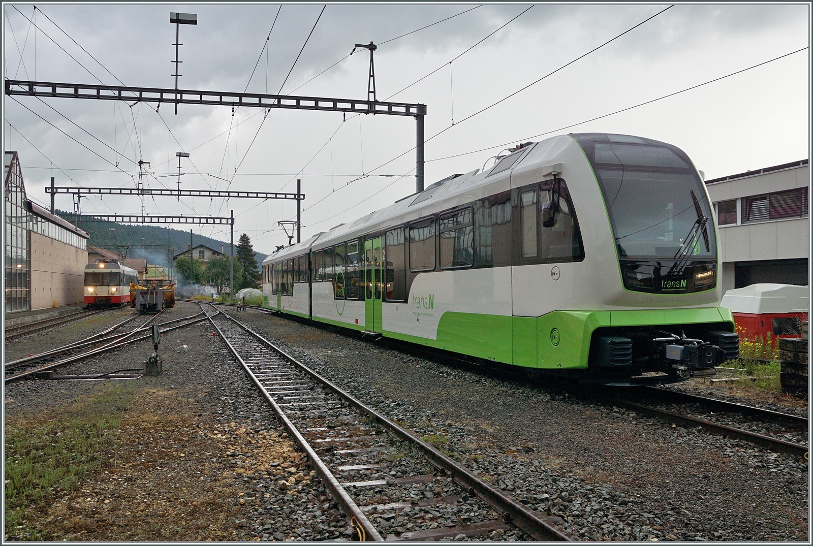 Der neue TransN ABe 4/8 N° 9 seht in Les Ponts de Martel, während für den Planverkehr zu diesem Zeitpunkt (noch) die beiden BDe 4/4 6 und 8 im Einsatz stehen, Links im Bild ist der ankommende BDe 4/4 N° 6 als Regionalzug R22 318 zu erkennen.

26. Juni 2024
