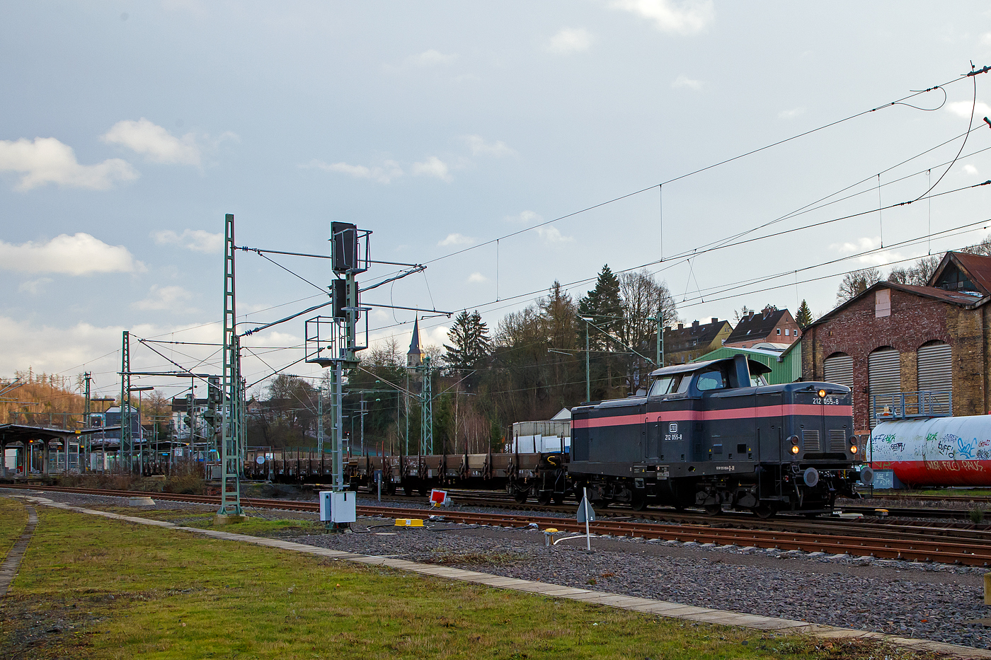 Die 212 055-8 (92 80 1212 055-8 D-JH) der JH - Joseph Hubert Bauunternehmung GmbH & Co. KG (Nürnberg) fährt am 11.01.2023 mit einem Langschienen Zug durch Betzdorf (Sieg) in Richtung Köln. Der Zug bestand aus Drehgestell-Flachwagen, mit Seiten-, Stirnwandklappen und Rungen, der Gattung Res 687, beladen mit Langschienen.

Die V 100.20 wurde 1963 von MaK in Kiel unter der Fabriknummer 1000191gebaut und als DB V 100 2055 an die Deutsche Bundesbahn geliefert. Zum 01.01.1968 erfolgte die Umzeichnung in DB 212 055-8, im Februar 2006 erfolgte die Ausmusterung bei der Railion Deutschland AG (heute wieder DB Cargo) und sie ging nach Ungarn an die LCH - Logistic Center Hungaria Kft. In Győr. Im Jahr 2012 ging sie zurück nach Deutschland an die ALS - ALSTOM Lokomotiven Service GmbH in Stendal, 2015 an Redler-Service und seit 2019 ist sie nun bei der Joseph Hubert Bauunternehmung.