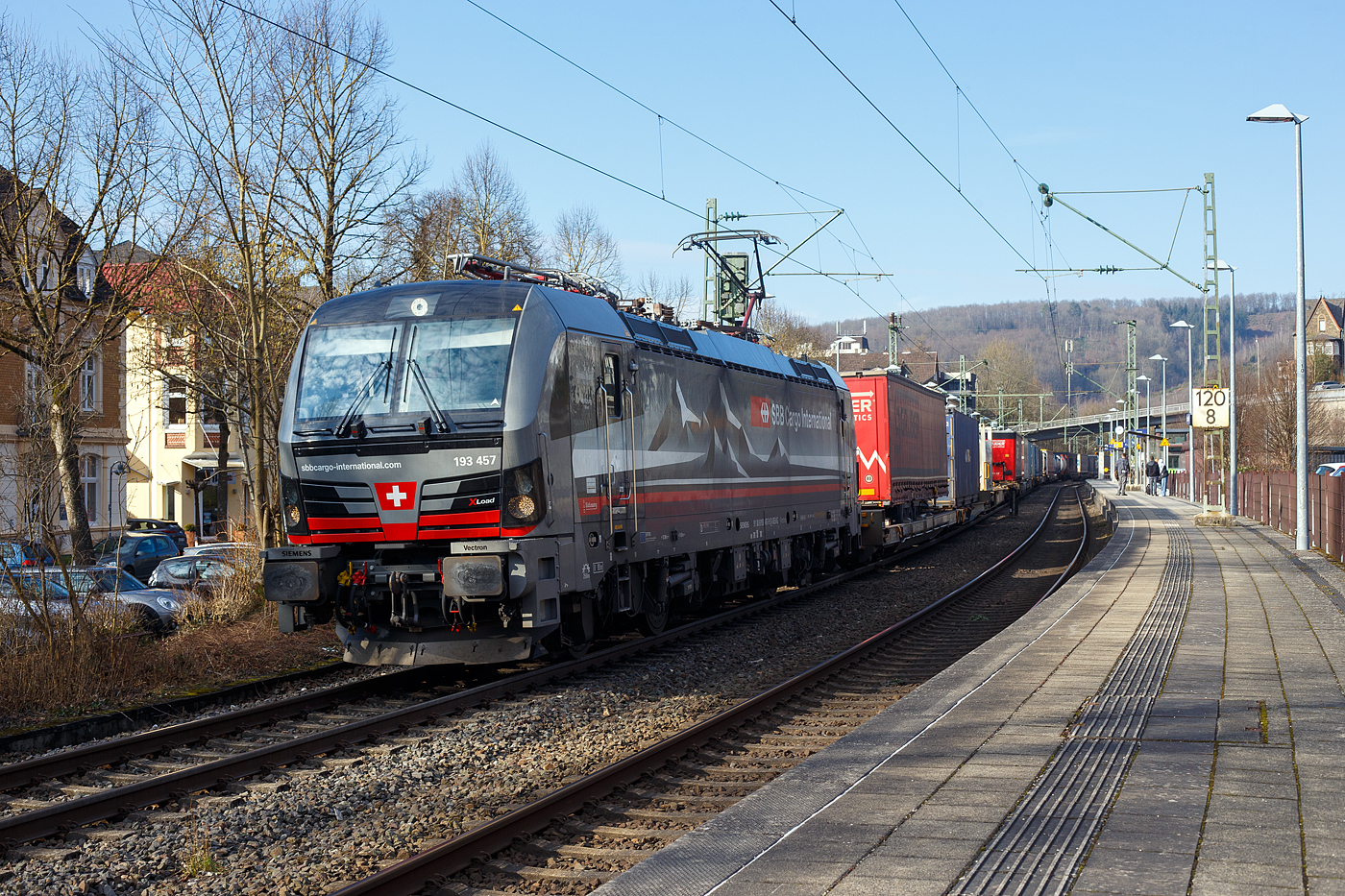 Die an die SBB Cargo International AG vermietete mit „XLoad“ ausgestattete 193 457  Hofburg Wien  (91 80 6193 457-9 D-SIEAG) der SüdLeasing GmbH, Stuttgart (eingestellt in Deutschland durch Siemens) fährt am 08 Februar 2025 mit einem KLV-Zug, durch Kirchen (Sieg) in Richtung Köln.

Die Multisystemlokomotive Siemens Vectron MS wurde 2024 von Siemens Mobilitiy in München-Allach unter der Fabriknummer 23785 gebaut und am 12.09.2024 ausgeliefert. Sie wurde in der Variante A40-1a ausgeführt und hat so die Zulassung für Deutschland, Österreich, die Schweiz, Italien, die Niederlande und Belgien (D / A / CH / I / NL / B). Sie verfügt über eine Leistung von 6,4 MW (160 km/h) und ist neben den nationalen Zugsicherungssystemen mit dem Europäischen Zugsicherungssystem (ETCS BL3) ausgestattet. Zudem ist sie mit der neuen Ausrüstungspaket XLoad ausgestattet. 

Das neue XLoad Ausrüstungspaket für Vectron:
XLoad ist ein Ausrüstungspaket für Vectron, welches künftig mitbestellt, aber auch bei bereits ausgelieferten Vectron Loks nachgerüstet werden kann. Das Feature verbessert die Reibwertausnutzung und ermöglicht dadurch höhere Anhängelasten. Zudem reduzieren die Fahreigenschaften, die das Feature bewirken, den Verschleiß von Rad und Schiene.

Aktuell sind die Schweizer Vectron-Lokomotiven (SBB Cargo und BLS Cargo) in der Regel in Doppeltraktion unterwegs. Die Steigungen und Rampen der Schweizer Berge sind vor allem bei schlechten Witterungsbedingungen nicht ohne. Eine Lokomotive muss auch bei geringerem Schlupf genügend Traktion auf die Schienen bringen, um alle Güter sicher und zuverlässig ans Ziel zu bringen. Ein effizienter Weg aus dieser «Misere» ist die für Vectron entwickelte Zusatz-Funktion «XLoad». Den erfolgreichen Beweis trat eine SIEMENS Testlokomotive im Frühjahr 2022 bei der SBB Cargo International und bei der BLS Cargo eindrücklich an. 

Für SBB Cargo International bewies die Test-Lokomotive am Bözberg und für BLS Cargo an der Nordrampe des Lötschbergs ihre enorme Zugkraft. 
Vectron meisterte im Frühjahr 2022 die lange 12‰-Steigung des Bözbergs mit einer Anhängerlast von 2.000 Tonnen bravourös. Bei den nächtlichen Testfahrten zeigte sich eindrücklich die enorme Zugkraft der Lokomotive. 

Am Lötschberg wurden bei der BLS Cargo steigungsmäßig noch ein paar Promille draufgepackt. Mit 1.020 Tonnen im Gepäck bewältigte die Vectron-Lokomotive mit XLoad-Feature die 27‰-Steigung der Nordrampe ebenfalls meisterlich. Und auch diverse Anfahrtsversuche absolvierte der mit dem XLoad-Feature aufgerüstete Vectron problemlos. 

So bestellte die SüdLeasing GmbH (Stuttgart) im Auftrag der SBB Cargo International jüngst 20 Vectron Lokomotiven mit XLoad bei SIEMENS.
