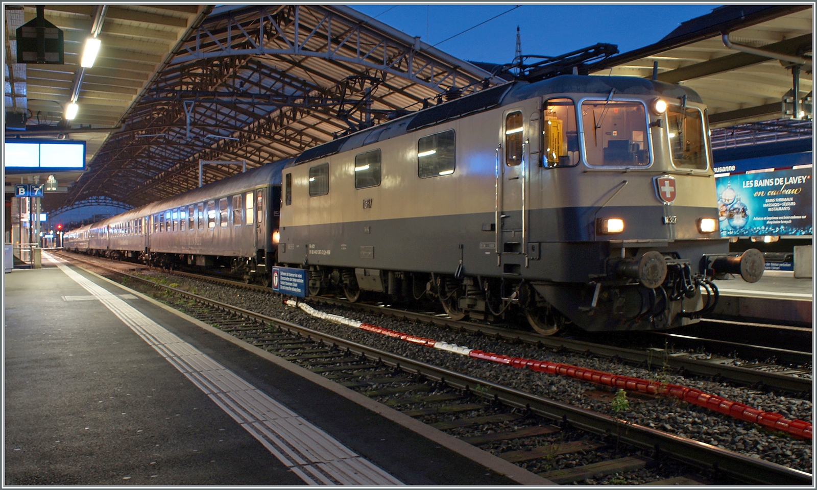 Die IRSI/IGE Re 4/4 II 11387 (Re 421 387-2) wartet mit ihrem ZRT Silvesterzug im Stile der Belle Epoque in Lausanne auf die Abfahrt nach Frankfurt am Main HBF. Es ist schon einige Zeit her, dass ich in Lausanne eine Re 4/4 II vor einem Reisezug fotografieren konnte. Die 1984 gebaute Re 4/4 II 11387 in der Rheingold-Farbgebung gefällt mir aber besonders gut. 

30. Dezember 2023