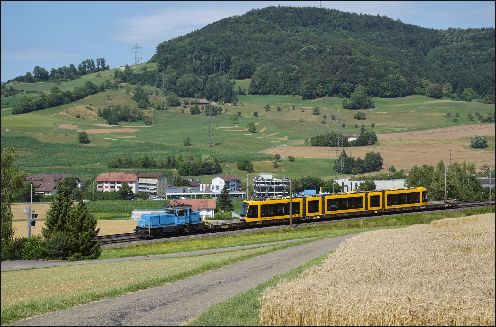 Die Stadler-Werkslok Eem 936 131 liefert eine neue TINA-Strassenbahn nach Darmstadt aus. Letztes Jahr auf der Innotrans ausgestellt, jetzt auf dem Weg zum Kunden in Frick, Juli 2023.