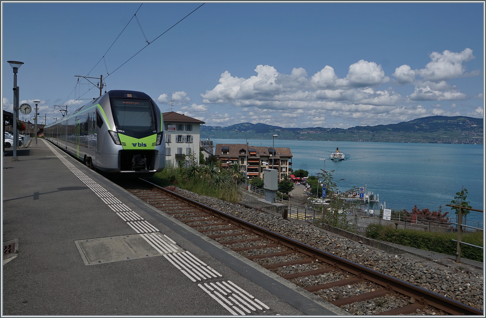 Durch strake Fahrgastzunahmen sah sich die RegionAlps gezwungen, bei der BLS einen RABe 528 zu mieten, welcher zwei RegionAlps Dominos freisetzt. Anfangs Frühling sah und fotografiere ich dann einen BLS RABe 528 und nahm mir vor im Sommer den Zug möglichst mit Schiff erneut zu fotografieren. Im Frühsommer stellte aber fest, dass der RABe 528 nicht mehr im gleichen Umlauf fährt und ich suchte ihn einige Zeit vergeblich in den Fahrplanunterlagen, so dass sich dachte, der Einsatz sei bereits beendet. Doch als mir gestern zufälligerweise ein BLS RABe 528 im Wallis entgengen kam, versuchte ich heute mein Glück in St-Gingolph: Während der BLS RABe 528 105  MIKA  als R91 6121 nach Brig auf die Abfahrt wartet, erreicht auf dem See das Dampfschiff LA SUISSE die Anlegestelle St Gingolph. Der Raddampfer ist als CGN Kursschiff 202/203 auf der Rundfahrt Lausanne Ouchy - St-Gingolph - Le Bouveret - Villeneuve - Vevey - Lausanne Ouchy.

24. Juli 2024 