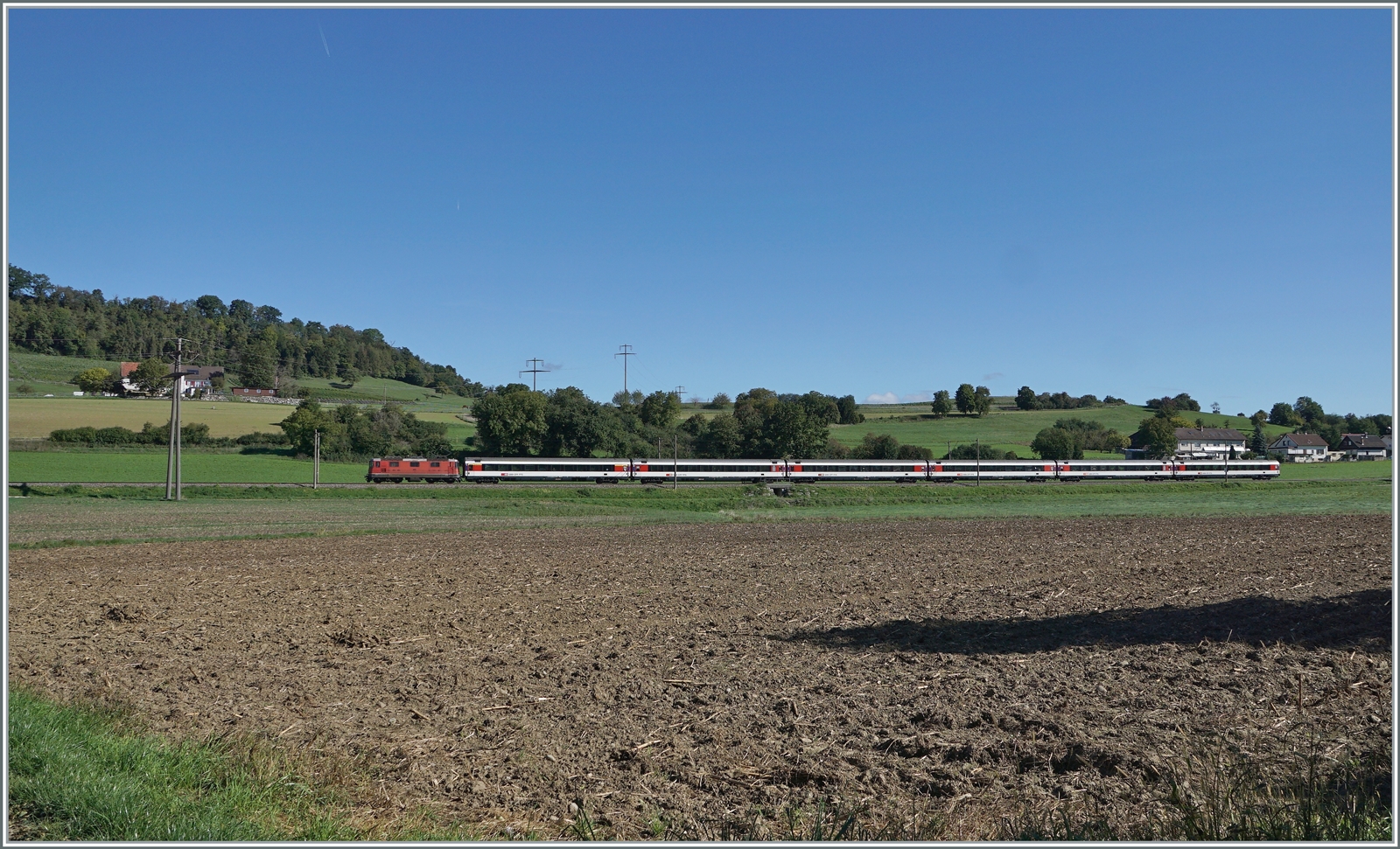 Ein Schweizer Zug in Deutschland, wenn auch nur noch für eine sehr kurze Zeit: Eine SBB Re 4/4 II ist mit einem IC von Singen nach Zürich bei Bietingen unterwegs und wird einige hundert Meter später die Grenze zur Schweiz erreichen. 

19. Sept. 2022