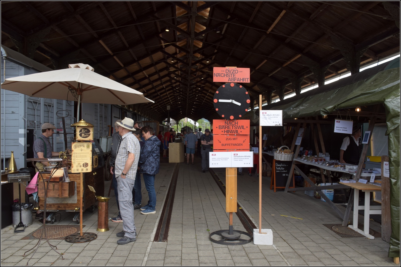 Fahrtag im Zürcher Oberland. 

Blick in die alte Basler Bahnhofshalle mit einem hübsch aufgemachten Kaffeestand am Eingang. Bauma, Juli 2023.