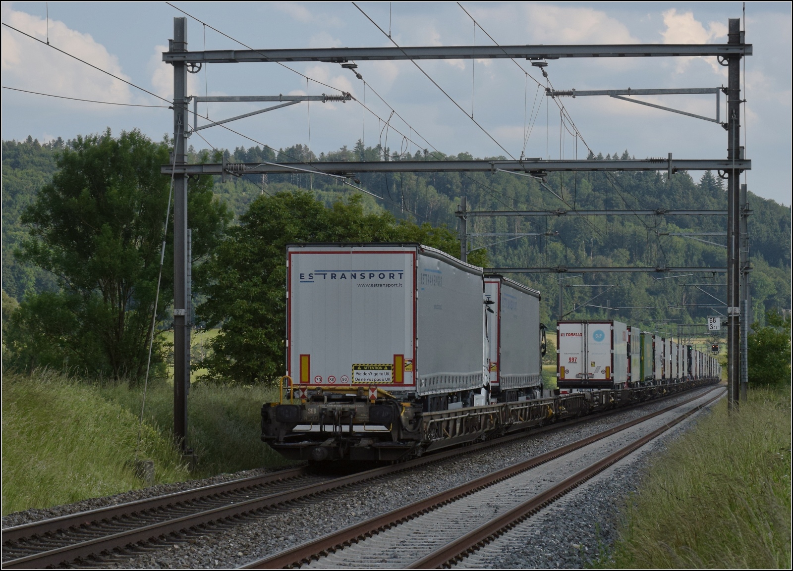 Fernverkehrstag auf der Altstrecke.

Via Burgdorf gibt es zumeist nur noch Güterverkehr, Nahverkehr und überregionale Züge nach Bern. Eine Rola tauchte noch auf mit Re 486 501. Interessant auch die Aufschrift am letzten Sattelzug:  We don't go to UK . Das unrühmliche Thema wird uns wohl so schnell nicht wieder verlassen. Bettenhausen, Juni 2023.