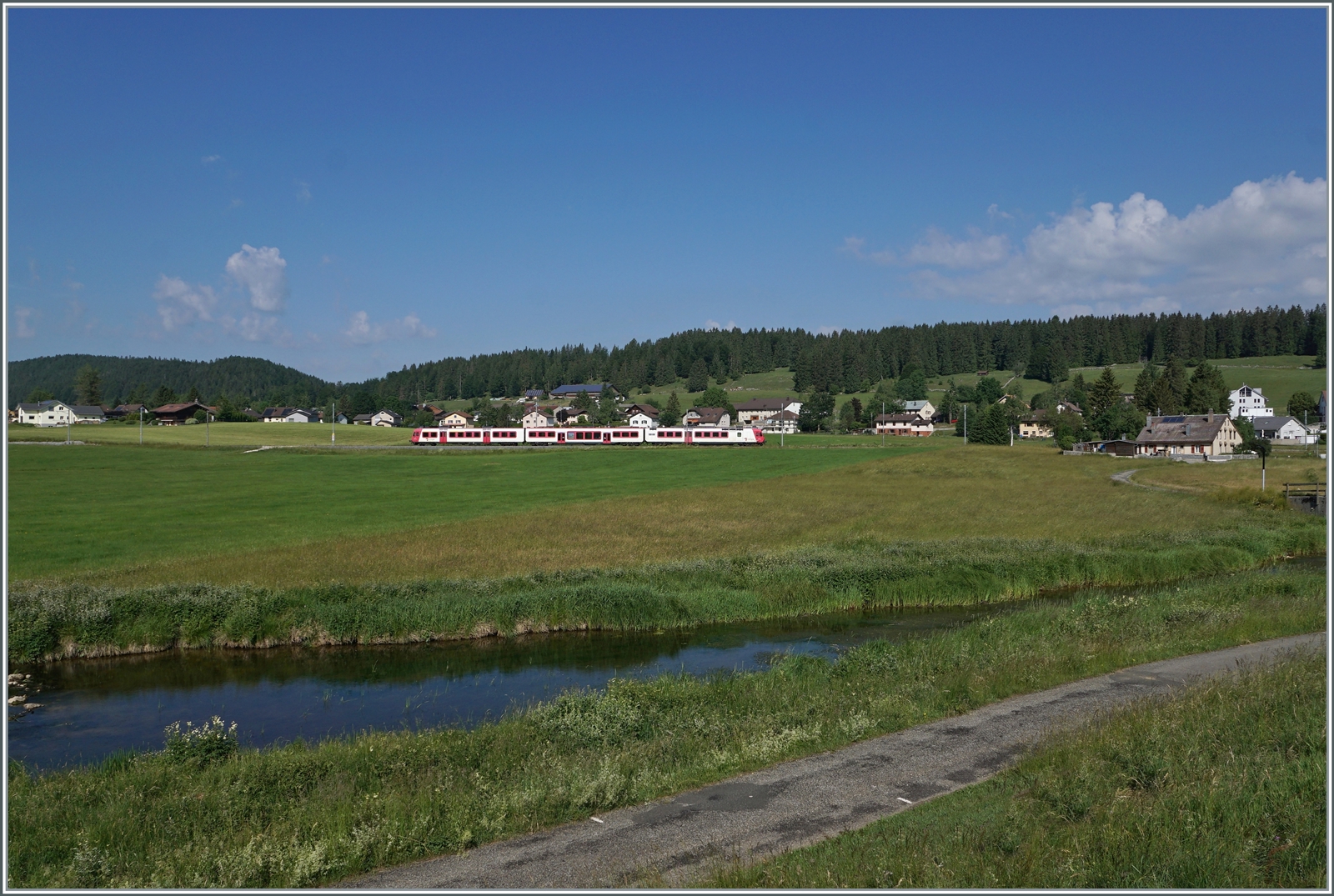 Kurz vor der Umstellung auf das neue Betriebskonzept mit den direkten Zügen Le Brassus - Aigle: Der TRAVYS RBDe 560 385-7 (RBDe 560 DO TR 94 85 7560 385-7 CH-TVYS)  Lac de Joux  ist als Regionalzug von Le Brassus nach Vallorbe unterwegs und konnte hier an der Orbe (links unten im Bild) zwischen Le Brassus und Sentier Orient fotografiert werden.

16. Juni 2022 