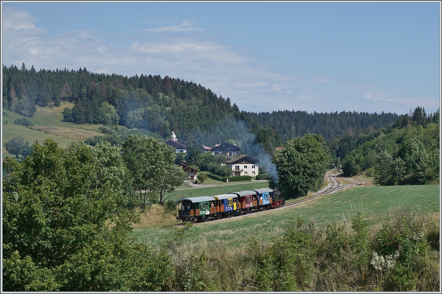 Mit einer unübersehbaren, aber nicht übermässgen Rauchfahne erreicht die ex E 3/3  Tigerli  mit ihrem Zug den Bahnhof von Le Touillon. 

15. Juli 2023 
