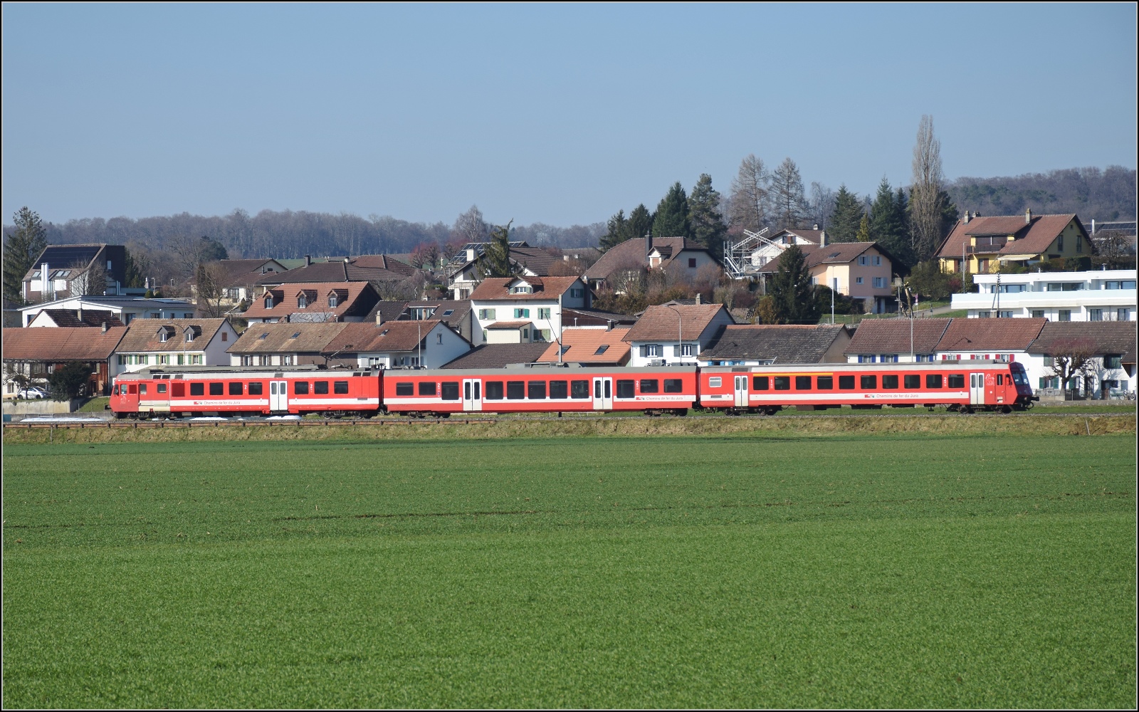 Noch ein bisschen Ajoie.

RABe 567 184 der CJ f�hrt an der Kulisse von Alle vorbei. Februar 2023.