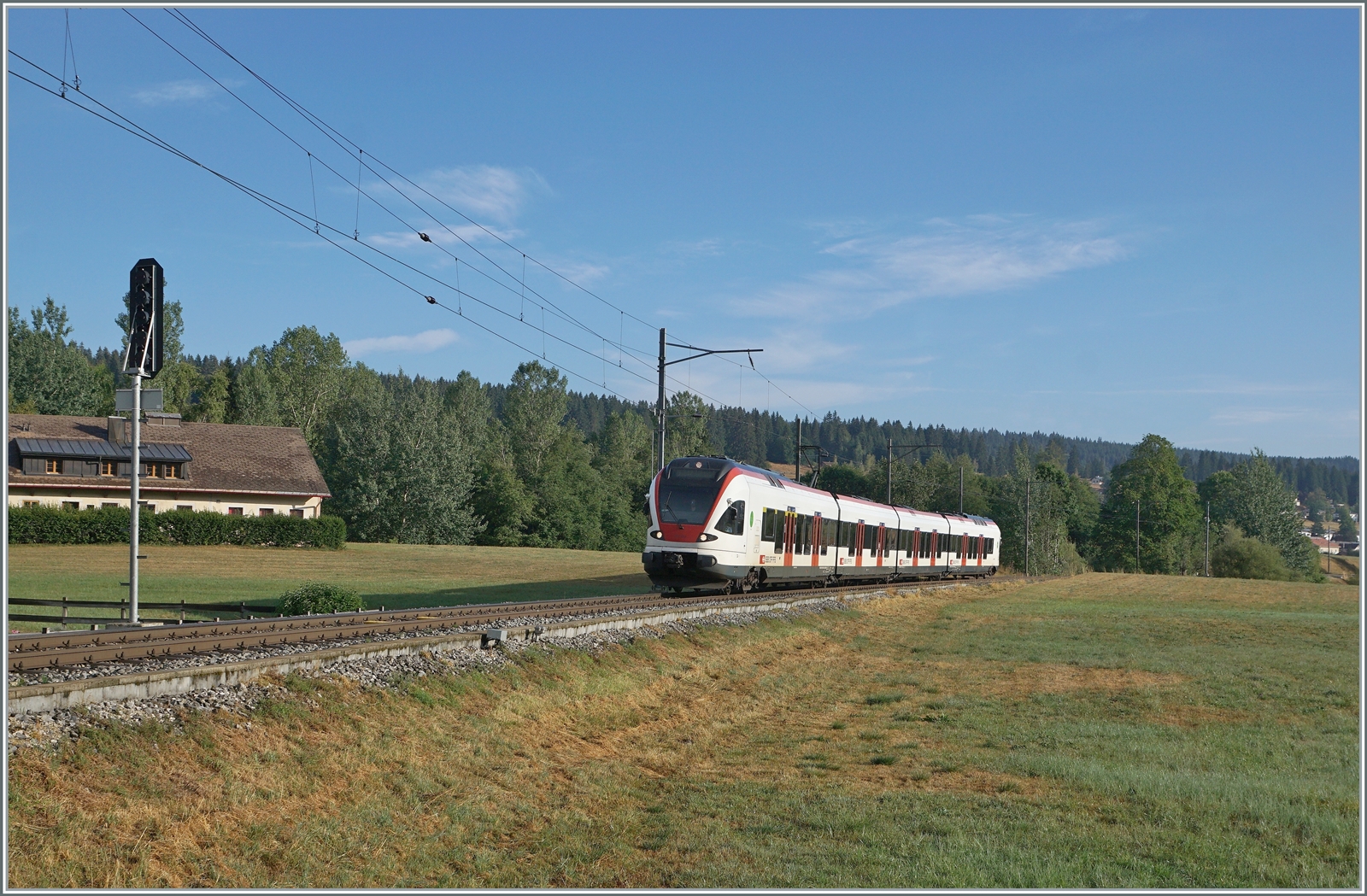 Nun haben auch wir unsere  Drei-Seen-Bahn : Die RER VAUD S2 Verbindung von Aigle nach Le Brassus verbindet nicht nur recht kontrastreiche Landschaften, sie führt auch an drei Seen entlang: dem Lac Léman, dem Lac de Brent und dem Lac de Joux. A propos Wasser: Während der Genfersee durch die Rhone ins Mittelmeer mündet, entwässert sich die Orbe in die Nordsee, der wenige Kilometer westlich von hier entspringende Doubs hingegen ins Mittelmeer. Das Bild zeigt den SBB RABe 523 022-7 (RABe 523 94 85 0 523 022-7 CH-SBB) als S2 24216 von Aigle beim Einfahrsignal von Le Brassus. 

15. August 2022