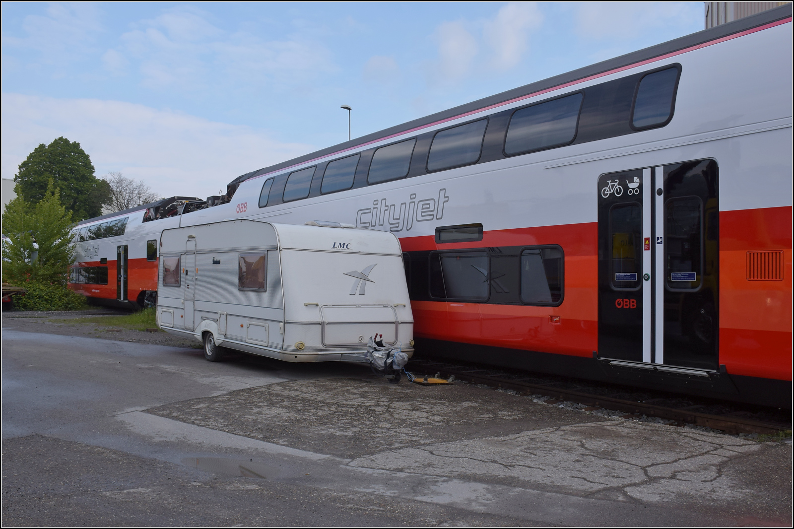 Rollout des ersten Kiss für die ÖBB.

Ziemlich knapp geht es erst mal an einem ungünstig abgestellten Wohnwagen vorbei, hier für den Zwischenwagen 7034 301. St. Margrethen, April 2024. 