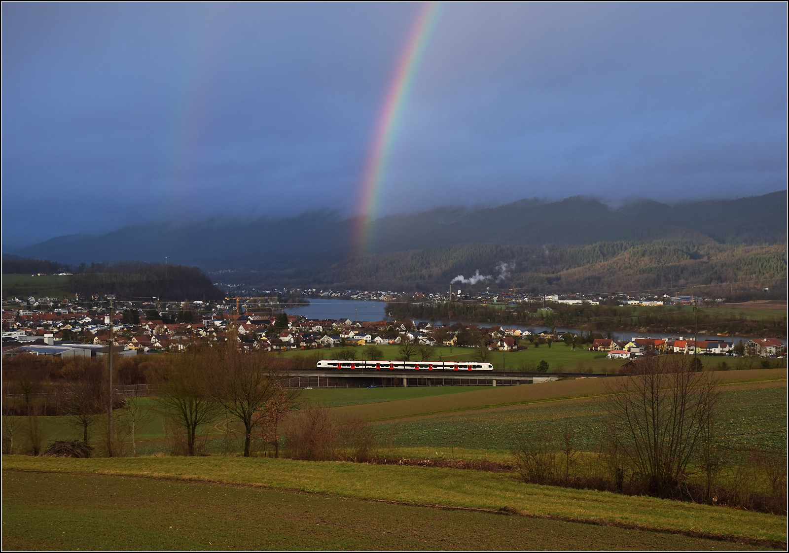 Schechtwetter in Mumpf. 

Noch bevor der Regenbogen verblasst, gibt es einen Nachschlag-Flirt RABe 523. Mumpf, Januar 2026.