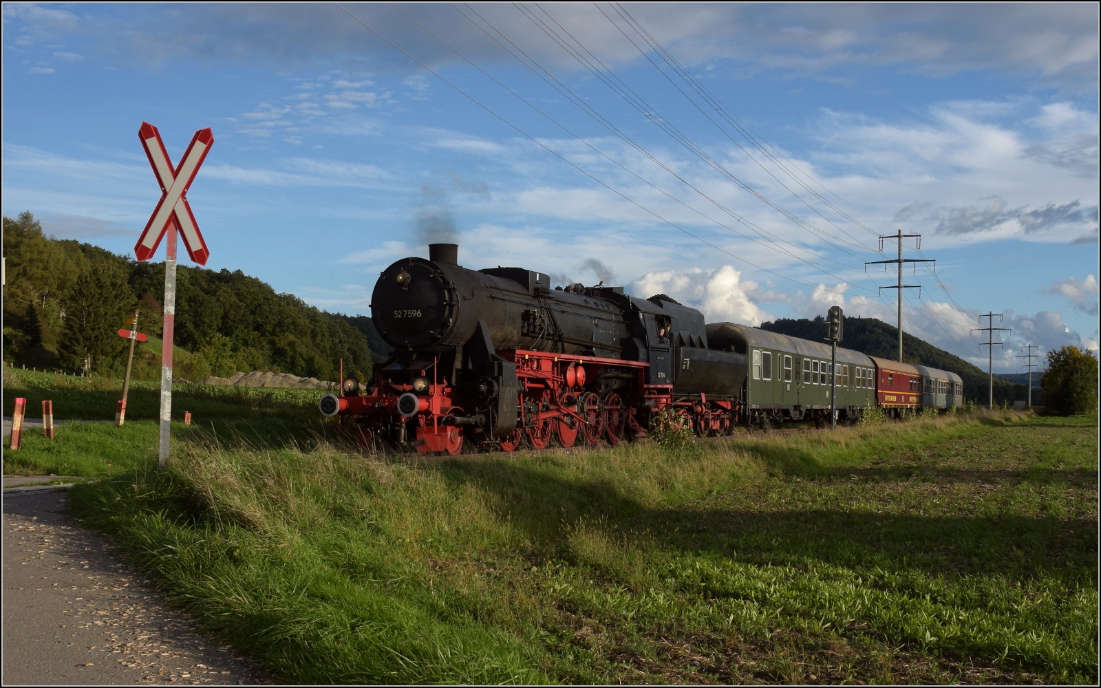 Schienenverkehr am Schienerberg. 

52 7596 mit ihrem EFZ-Sonderzug für die SEHR&RS zwischen Hemishofen und Ramsen auf der letzten Fahrt des Tages. Oktober 2022.