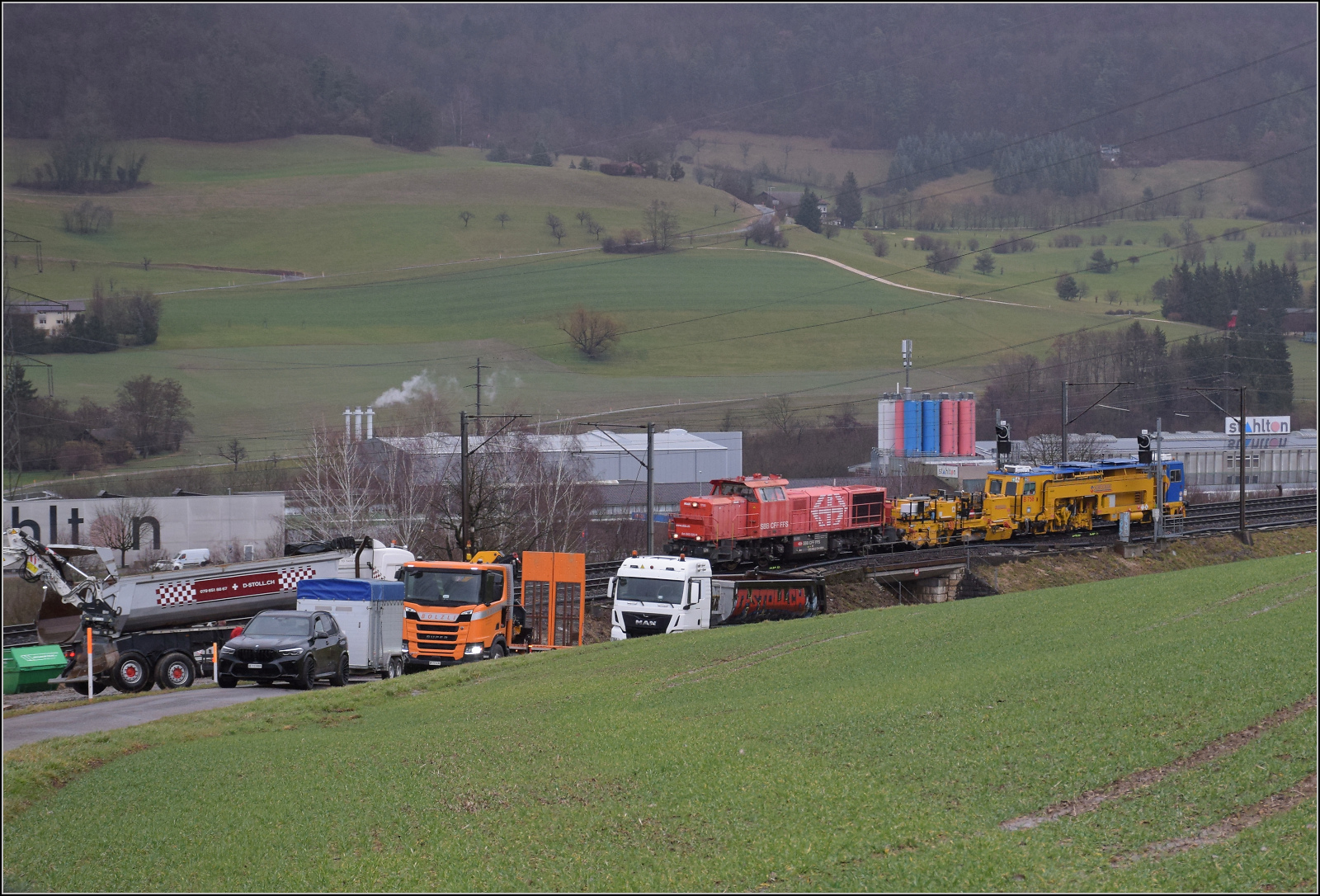 Schlechtwetter und ein Baustellendrama bei Frick. 

Am 843 020 der SBB Infrastruktur fährt mit einer Nivelier-Richt-Stopfmaschine B 758 von Scheuchzer (CH-SCHEU 40 85 9581 078) und dessen Anhänger B 762 zum Bürsten des Schotterbetts ist offenbar auf einer Drehfahrt von Brugg zurück nun in Richtung Basel. Februar 2026.