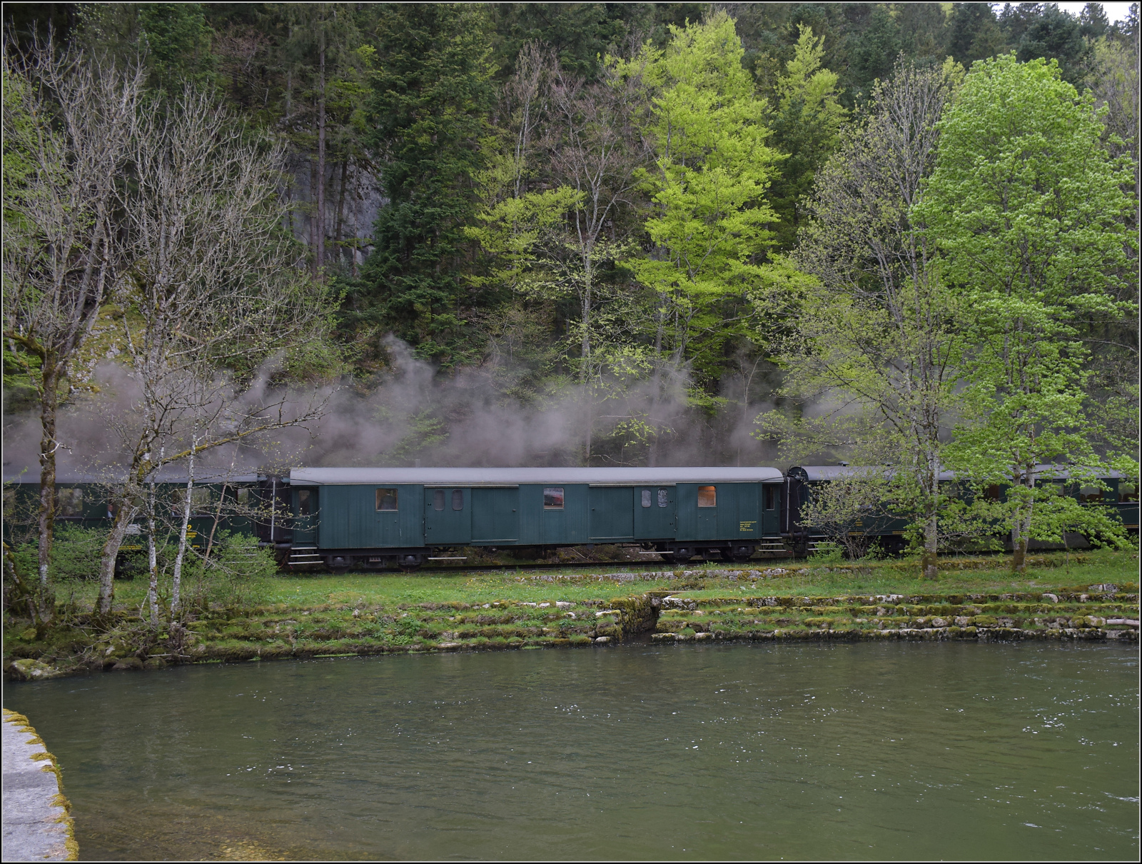 Train du Terroir.

Gep�ckwagen F4� 11827  auf dem Laufsteg  entlang der Areuse zwischen St-Sulpice und Fleurier. Mai 2024.
