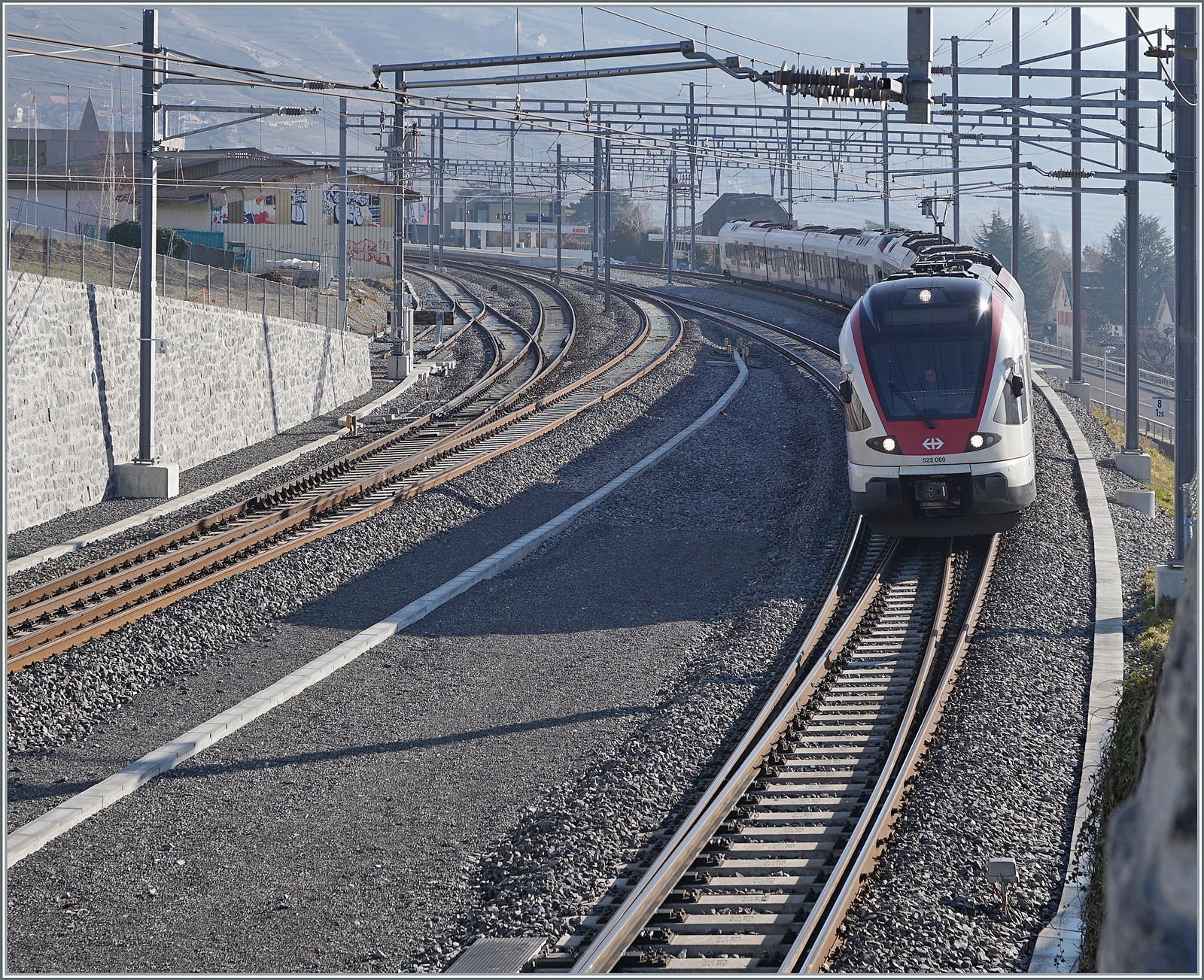 Um den RER Vaud S-Bahnen ein wenden in Cully zu ermöglichen hat man den Bahnhof umgebaut: das Bergseitige Gleis im Einfahrbereich etwa gestreckt und gegen den Berg verschoben, das ehemalige Durchfahrgleis hat nun Seite Lausanne Weichenverbidnungen ohne den Gengenverkehr zu beeinträchtigen und as ehemalige Überholgeleis ist nun das Durchfahrtgleis Richtung Lausanne. 

Im Bild Zwei SBB RABe 523 auf dem Weg in Richtung Lausanne. Dieser Zug kommt von Aigle, nutze also das Gleis 3. 

20. Feb. 2023
