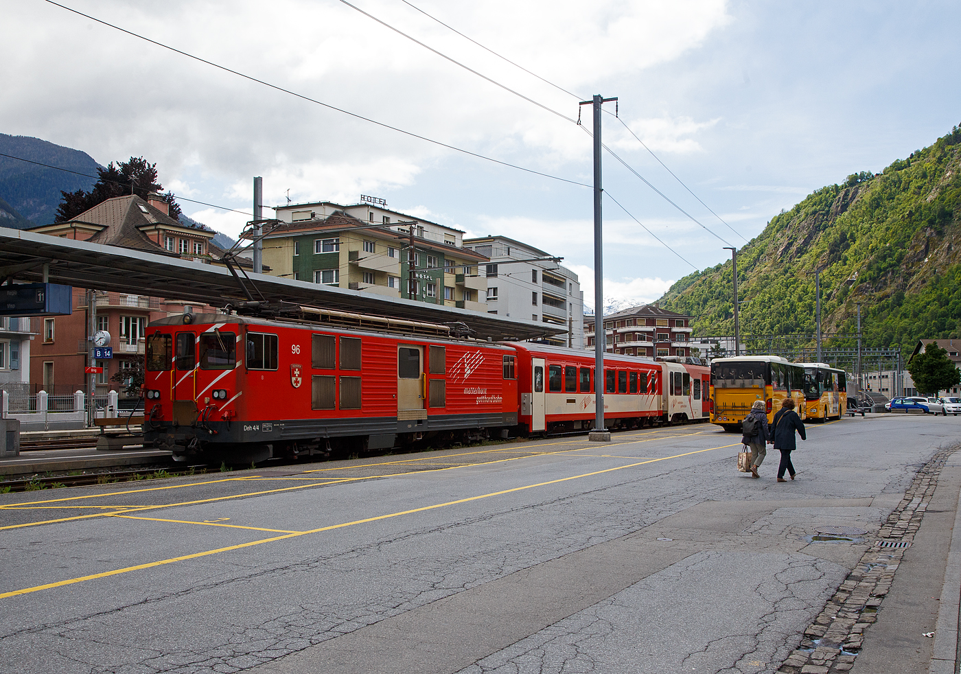 Von dem Gepäcktriebwagen Deh 4/4 II - 96  Münster   der Matterhorn-Gotthard-Bahn (MGB), ex FO 96  Münster   (Furka-Oberalp-Bahn), geschoben verlässt am 25.05.2023 der Regionalzug von Andermatt nach Visp den Bahnhof (Vorplatz) Brig.

Der Gepäcktriebwagen wurde 1984 von SLM (mechanischer Teil, Lokomotivkasten) und BBC (elektrische Ausrüstung) gebaut.