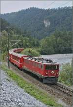Die Rhb Ge 6/6 II 702 mit einem RE von Disentis nach Scuol in der Rheinschlucht bei Versam-Safien.