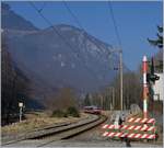 Ein RegionAlps Regionalzug nähert sich dem Château de la Porte de Scex und dessen nahegelegen Bahnübergang.