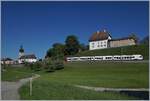 Links im Hintergrund die Kirche von Vaulruz, im oberen Bildteil das Schloss und mitten drin ein TPF RBDe 527 auf dem Weg nach Bulle.