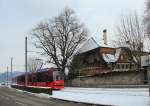 Berner Strassenbahnwagen 765 (Combino) auf der RBS (Regionalverkehr Bern-Solothurn) vor dem Geb�udekomplex des Schlosses Muri, 21.Januar 2016.