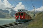Im Schatten einer Wolke fahrt der Bernina ABe 4/4 N� 53 mit einem Schwestertriewagen  und einem langen Regionalzug nach Tirano am Lac Bianco entlang und erreicht in K�rze Ospizio Bernina.