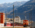Rechts steht das RhB  Eselchen  161 bzw. der Rangiertraktor RhB Ge 2/2 161, ex BB Ge 2/2 61. Hinten steht der 3-teilige RhB ALLEGRA-Zweispannungstriebzug (RhB ABe 8/12) 3515  Alois Carigiet  mit 5 angehangenen Personenwagen zur Abfahrt als RhB Region nach St. Moritz bereit. 